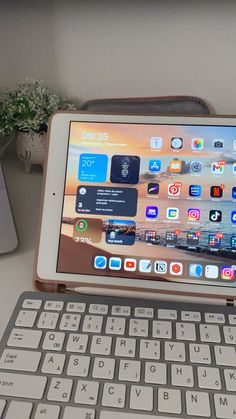 an ipad sitting on top of a desk next to a keyboard