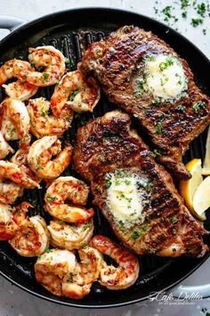 steak and shrimp with lemon wedges in a cast iron skillet