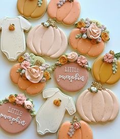 baby shower cookies decorated to look like pumpkins and other fall themed items are arranged on a white surface