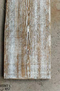 an old weathered wooden plank hanging on the wall