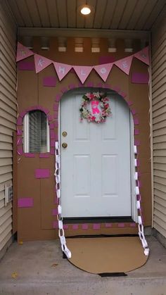 a front door decorated with pink and white decorations