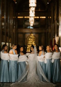 a bride and her bridal party in front of a christmas tree