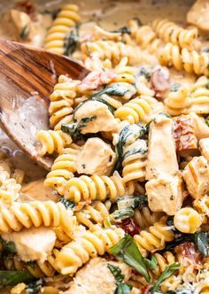 a pan filled with pasta, chicken and spinach