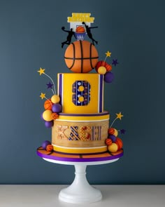 a three tiered cake decorated with basketballs and stars