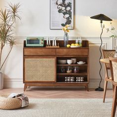 a living room with a table, chair and pictures on the wall