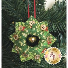 a green christmas ornament hanging from a tree