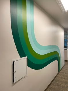 an office hallway painted in green and white with a light switch box on the wall