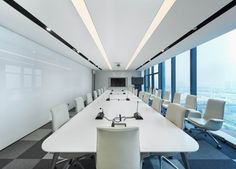 an empty conference room with white tables and chairs