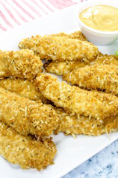 fried chicken sticks on a white plate with dipping sauce