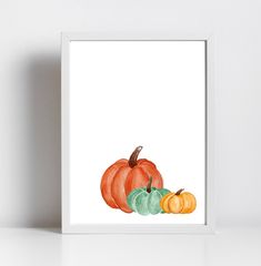 a watercolor painting of three pumpkins on a white background, with one orange and the other green