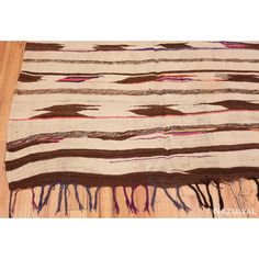 a brown and white striped rug on top of a wooden floor