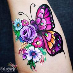 a colorful butterfly with flowers on it's arm