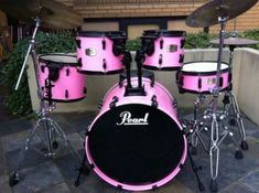 a pink drum set sitting on top of a stone floor