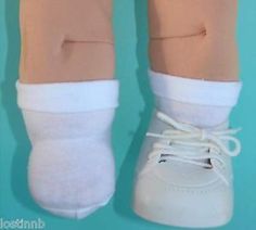 a doll's legs and feet are shown with white shoes on top of them