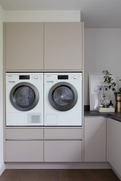 a washer and dryer in a room with wood flooring on the side