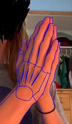 a woman holding her hands up in front of her face with blue lines on it