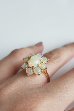 This gold ring features beautiful opals set in a prong setting in cluster. RING DETAILS: ✪Design: Gold cluster ring ✪Gemstone: Natural opal ✪Gemstone color: White ✪Gemstone shape: Oval, round ✪Gemstone size: 6mm*8mm, 4mm ✪Gemstone weight: 2.35 cts. ✪Setting type: Prong setting ✪Metal type: 14k solid gold ✪Gold weight: 2.91 gm ✪Metal finish: Smooth shiny ✪Total ring weight: 3.38 gm Choose your ring size from drop down menu and if you need any other preferred ring size please contact us. QUALITY O Cluster Multi-stone Opal Ring For Anniversary, Elegant Cluster Opal Ring, Elegant Multi-stone Cluster Opal Ring, October Birthstone Ring, October Birthstone Rings, Ring Cluster, Engagement Ring For Women, Cluster Engagement Ring, Cabochon Ring