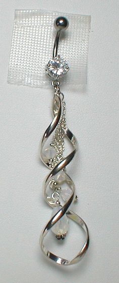 a silver colored metal object hanging on a white wall with a clear plastic tag attached to it