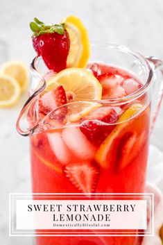 a pitcher filled with lemonade and strawberries