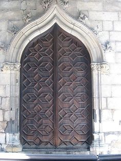 an ornate wooden door on the side of a building