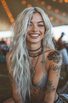 a woman with tattoos on her arm and chest sitting in front of a carousel ride