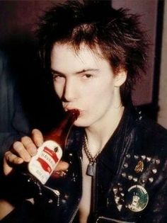 a man in leather jacket drinking from a bottle