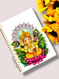 a notebook with an image of the god ganesh on it next to sunflowers