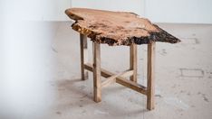 a piece of wood sitting on top of a white floor next to a wooden table