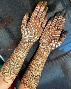 two hands with henna tattoos on them