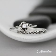 "This beautiful Sterling Silver Rose and Swirl Bridal Set includes two individual Sterling Silver bands: a sculptural rose ring that features a sparkling 3 mm round stone weighing approximately .15 carats and a narrow pattern wire band with a beautiful, curling pattern. We are happy to create this set for you in a variety of sizes, stone choices, and finish options. For the Rose Ring: This ring features a beautiful Sterling Silver rose that blooms from the top of the band and holds a 3 mm (appro Elegant Sterling Silver Ring With Rose Design, Elegant Silver Rings With Rose Design, Wedding Jewelry With Rose Design In Sterling Silver, Wedding Sterling Silver Jewelry With Rose Design, Sterling Silver Rose Flower Ring For Wedding, Wedding Rings In Rose Sterling Silver, Sterling Silver Rose Design Jewelry For Wedding, Silver Wedding Jewelry With Rose Design, Rose Flower Ring In Sterling Silver For Wedding