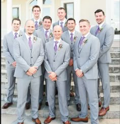 a group of men standing next to each other in front of a white house wearing suits and ties