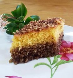 a piece of cake sitting on top of a white plate next to a pink flower