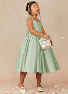 Let your flower girl have fun walking down the aisle while tossing petals in our Matte Satin A-line dress, Cutie Pie. Her square neckline is ruched beautifully and has elastic straps. The back ties into a beautiful bow while the gathered skrit is perfect for twirling an dancing. This dress is not only perfect for a flower girl at a wedding but also versatile enough for other special occasions. Sage Flower Girl Dress, Satin Flower Girl Dresses, Sage Green Wedding Theme, Green Flower Girl Dresses, Sage Green Flowers, Gigi Dress, Satin Flower Girl Dress, Wedding Dresses For Kids, Green Themed Wedding