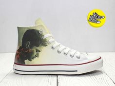 a pair of white converse shoes with the image of a woman's face painted on them