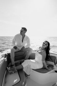 a man and woman sitting on the back of a boat