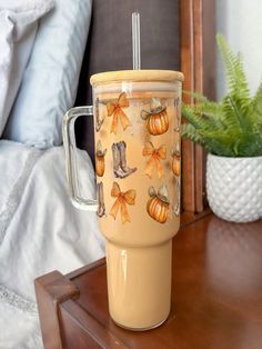 a coffee cup sitting on top of a wooden table next to a potted plant