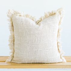 a white pillow sitting on top of a wooden table