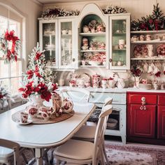 a dining room table and chairs in front of a china cabinet with christmas decorations on it