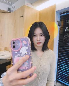 a young woman taking a selfie with her cell phone in front of her face