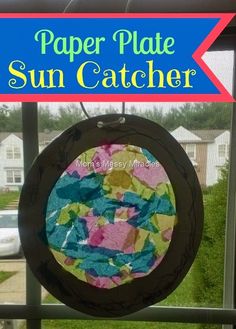 a paper plate sun catcher hanging on a window sill