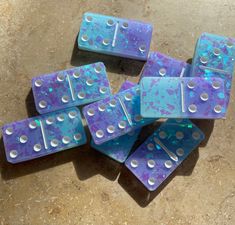 purple and blue dominos laying on the ground next to each other with holes in them