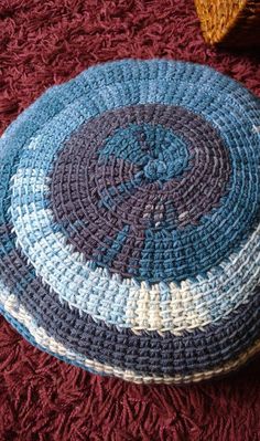 a crocheted blue and white hat sitting on top of a red blanket