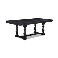 a black dining table with wooden legs and an ornate design on the top, against a white background