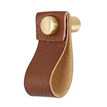 a brown leather door handle with a brass plate on it's end and an oval hole in the middle