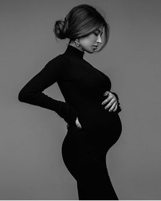 a pregnant woman poses in a black dress