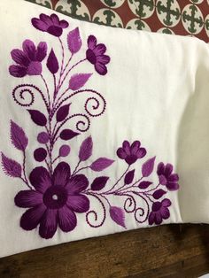 a pillow with purple flowers embroidered on it