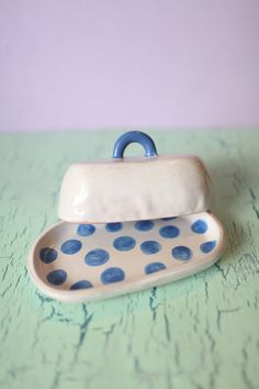 a blue and white polka dot dish on a green table