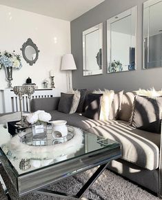 a living room filled with lots of furniture and mirrors on the wall above it's coffee table