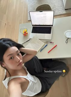 a woman sitting at a desk with a laptop computer