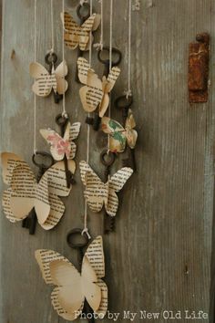 some butterflies are hanging from the side of a wooden door with old book pages attached to them